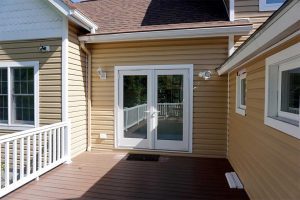 A French patio door on a home with yellow siding.