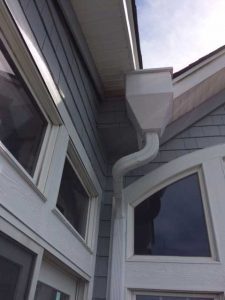 A close-up of a gutter downspout on a house.